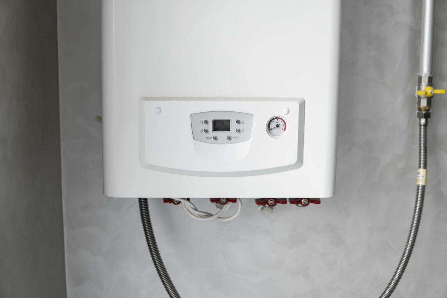 White modern home gas boiler mounted on a grey wall on a kitchen. Water heater. Water heating, ecology. White modern home gas boiler mounted on a grey wall on a kitchen. Water heater. Water heating, ecology